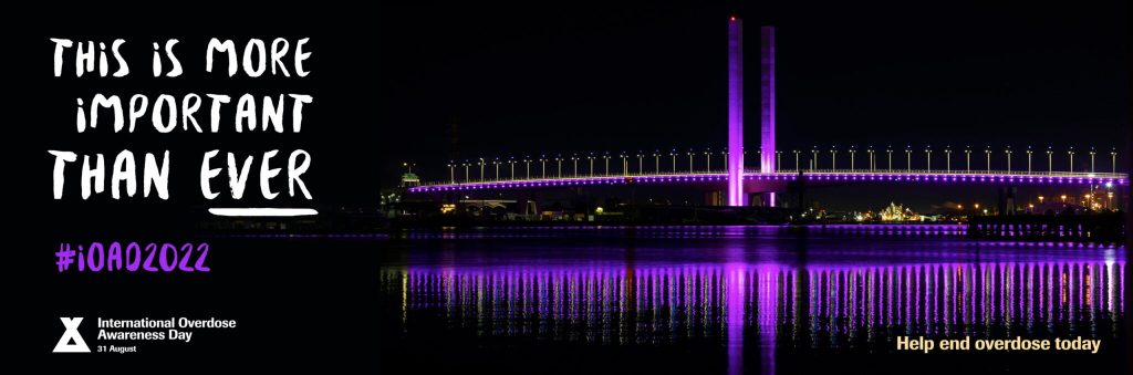 Bridge lit up in purple for overdose awareness. Image reads Time is more important than ever. 
